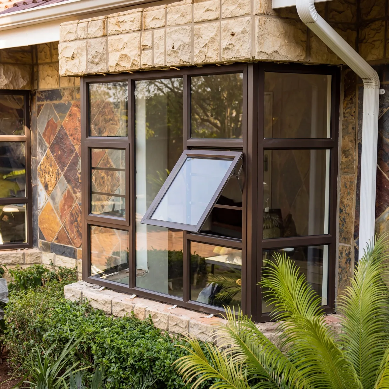 Stone-clad corner window installation with black aluminium frames in Krugersdorp