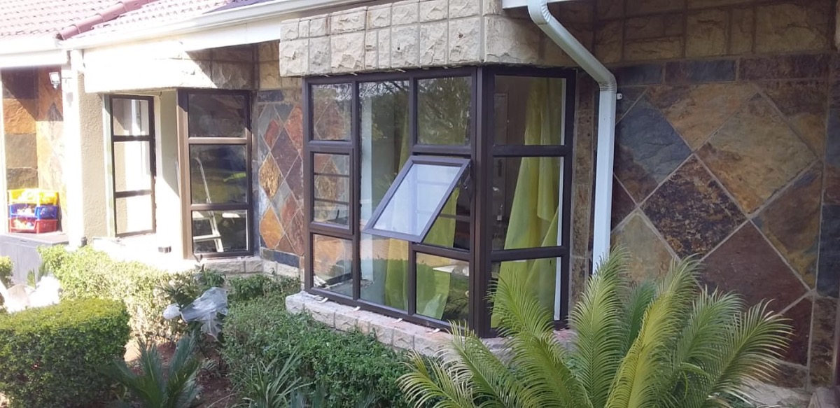 charcoal aluminium frames on a natural stone-clad home